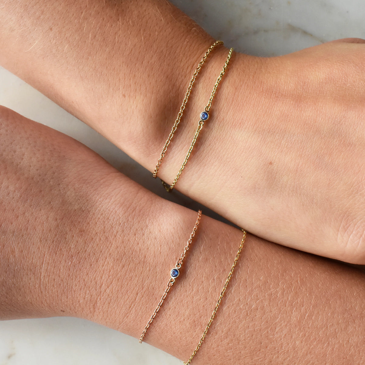 women wearing permanent bracelets with gemstone charms